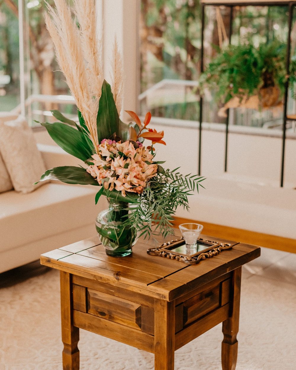 Cozy interior corner with botanical wallpaper and a soft floral arrangement