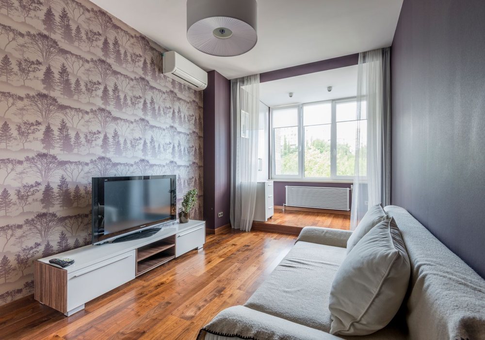 Living room with a grey woodland-toile wallpaper accent wall behind the media unit