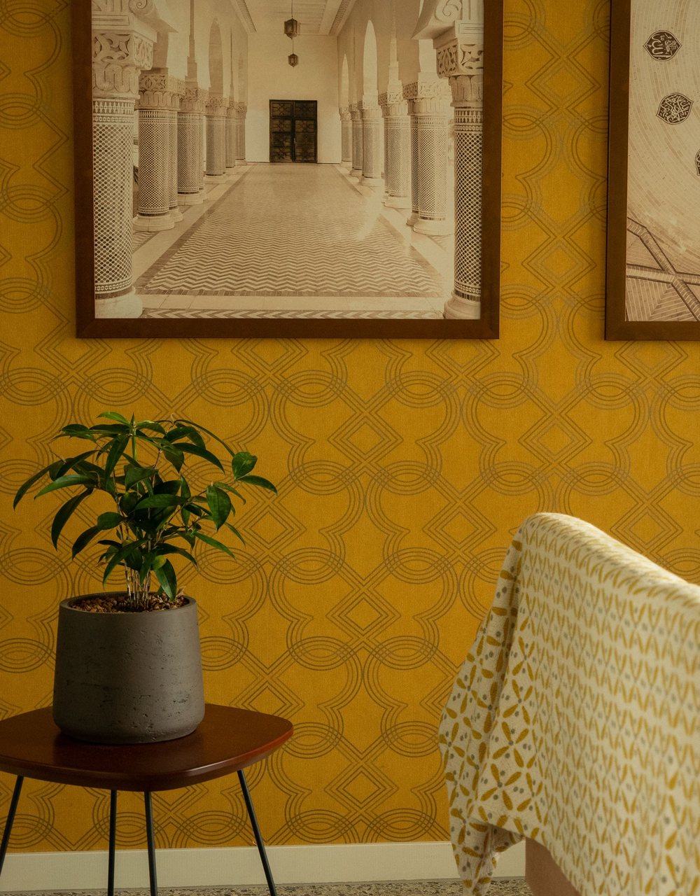 Home-office reading nook with a warm ochre geometric wallpaper wall