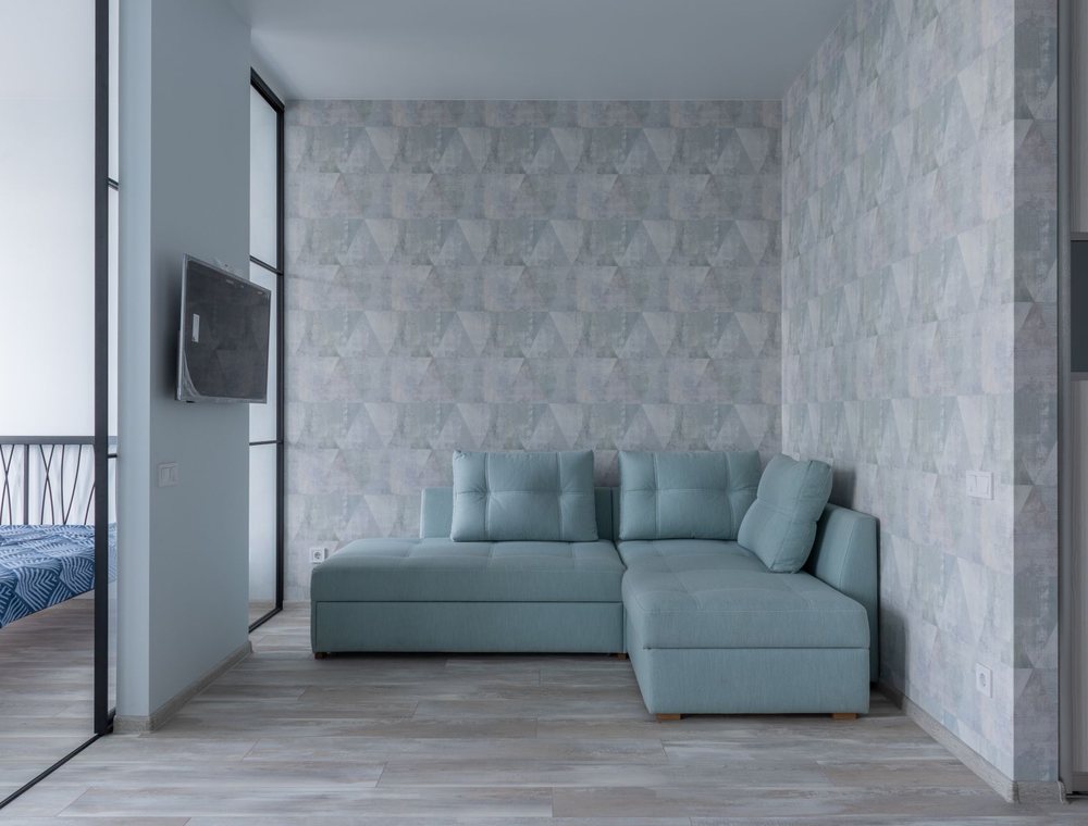Contemporary living area with a pale geometric wallpaper feature wall