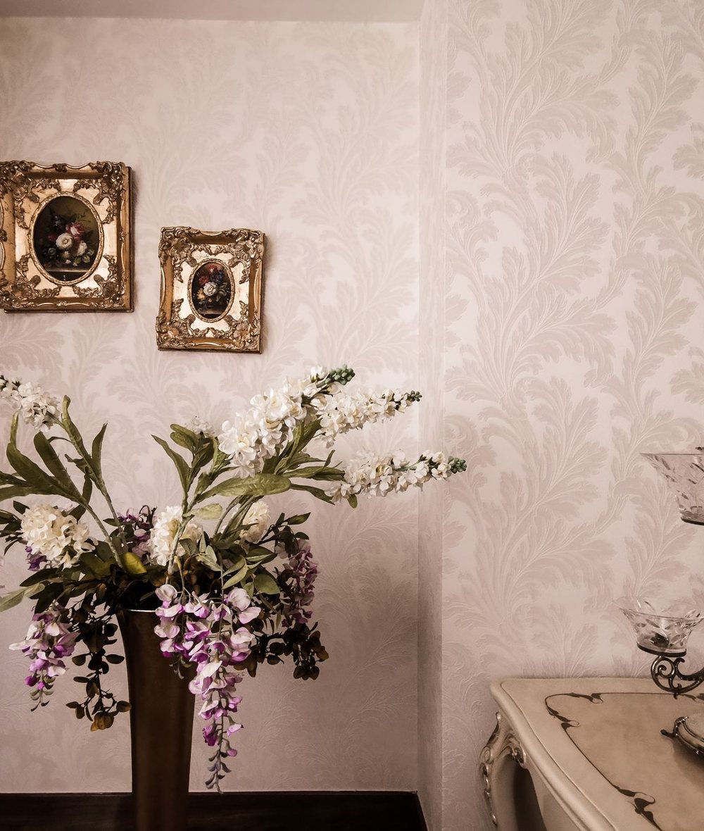 Classic interior with floral damask wallpaper and gilded picture frames