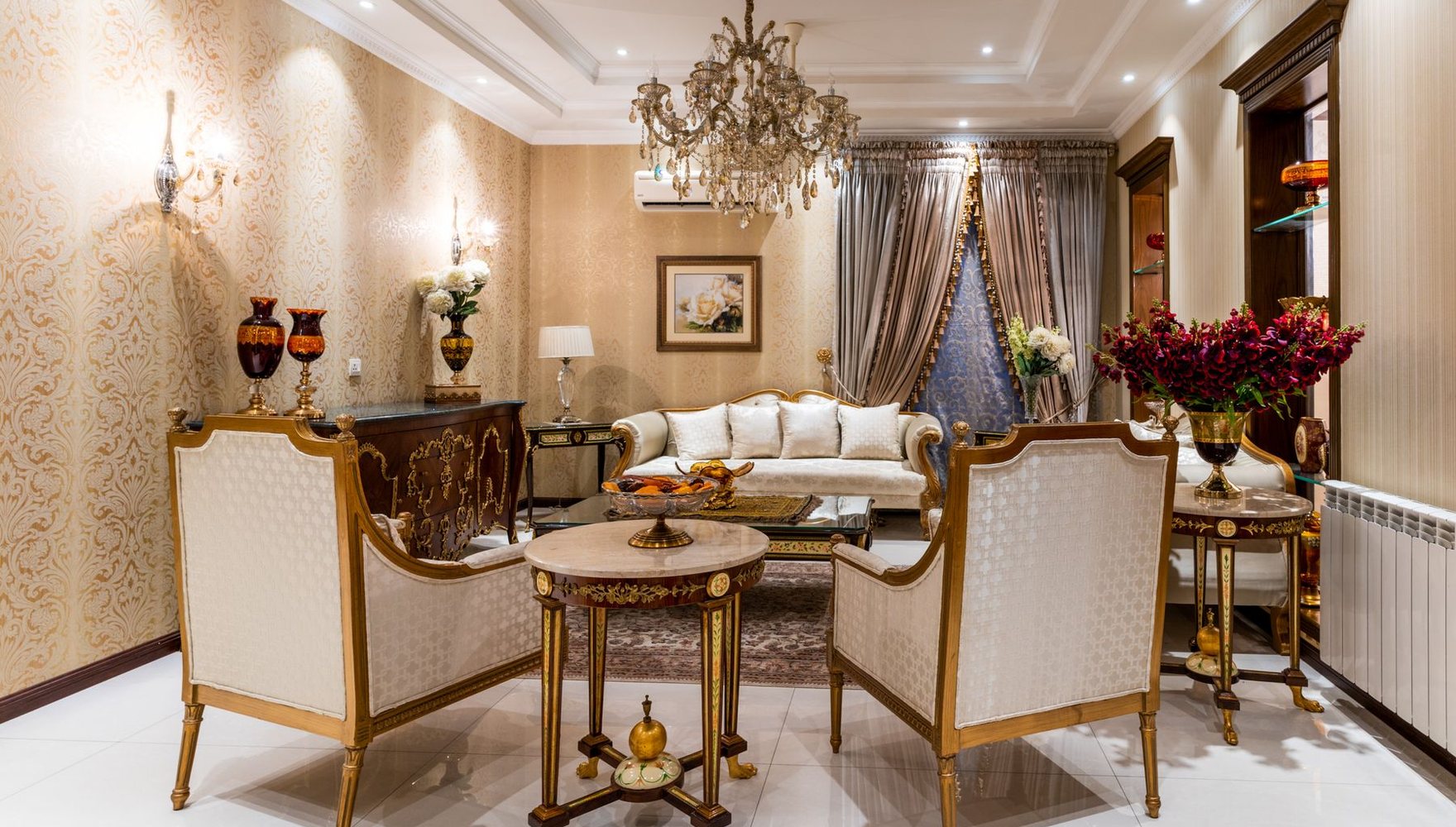 Elegant living room with cream damask wallpaper, gilded seating, and a chandelier